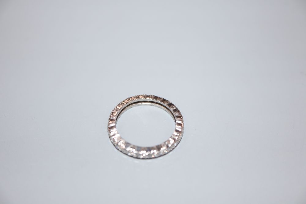 A white metal and diamond set full eternity ring, size M, gross 3.3 grams.